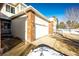 Exterior of a two-car garage with brick accents and a snow-covered yard in a residential neighborhood at 3383 Mount Royal Dr # 46, Castle Rock, CO 80104