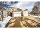 Exterior view of garages, featuring brick and siding and individual driveways partially covered in snow at 3383 Mount Royal Dr # 46, Castle Rock, CO 80104