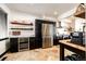 Modern kitchen featuring stainless steel appliances, black cabinets, travertine floors, and floating wood shelves at 3383 Mount Royal Dr # 46, Castle Rock, CO 80104