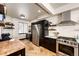 Bright kitchen with stainless appliances, travertine tile, wood island, open shelving, and ample counter space at 3383 Mount Royal Dr # 46, Castle Rock, CO 80104