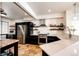 Modern kitchen with open shelving, stainless steel appliances, quartz counters, and travertine floors at 3383 Mount Royal Dr # 46, Castle Rock, CO 80104