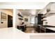 Stylish kitchen with breakfast bar, dark cabinets, stainless appliances, and wood floors at 3383 Mount Royal Dr # 46, Castle Rock, CO 80104