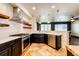Modern kitchen with stainless steel appliances, dark cabinetry, tile flooring, and stylish pendant lighting at 3383 Mount Royal Dr # 46, Castle Rock, CO 80104