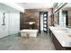 Spa-like bathroom with a soaking tub, walk-in shower, dual vanities, and access to a spacious walk-in closet at 29822 Troutdale Scenic Dr, Evergreen, CO 80439