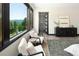 Relax in the cozy sitting area with stunning mountain views, a perfect retreat within the spacious bedroom at 29822 Troutdale Scenic Dr, Evergreen, CO 80439