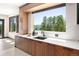 Modern kitchen featuring wooden cabinets, an island, and a large window with a view at 29822 Troutdale Scenic Dr, Evergreen, CO 80439