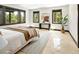 Main bedroom featuring three large windows boasting wooded views, cozy rug, and tasteful decor at 29822 Troutdale Scenic Dr, Evergreen, CO 80439
