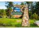 Welcome to Evergreen sign; stone monument surrounded by trees, cars, and green grass at 29822 Troutdale Scenic Dr, Evergreen, CO 80439