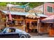 The Wildflower Cafe with outdoor seating, stone and wood exterior, and a classic car parked nearby at 29822 Troutdale Scenic Dr, Evergreen, CO 80439