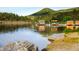 Scenic lake view with paddle boats docked; framed by serene water, lush trees and rugged rocks at 29822 Troutdale Scenic Dr, Evergreen, CO 80439