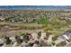 Wide aerial view of a neighborhood with a golf course, many houses and mountains in the background at 9531 Desert Willow Way, Highlands Ranch, CO 80129