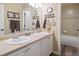 Bathroom features dual sinks, a shower over tub, and decorative towel racks at 9531 Desert Willow Way, Highlands Ranch, CO 80129