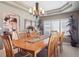 Elegant dining room with a large wooden table, stylish chandelier, and plenty of natural light, ideal for entertaining at 9531 Desert Willow Way, Highlands Ranch, CO 80129