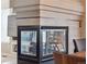 Modern see-through fireplace with stone surround and black trim accents the dining room at 9531 Desert Willow Way, Highlands Ranch, CO 80129