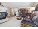 Spacious living room with fireplace, leather furniture, and view of office and entryway at 9531 Desert Willow Way, Highlands Ranch, CO 80129