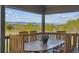 Covered patio featuring an outdoor dining set, perfect for enjoying meals with views of the surrounding trees and distant mountains at 9531 Desert Willow Way, Highlands Ranch, CO 80129