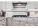 Gas stovetop featuring white cabinets and granite countertops at 9531 Desert Willow Way, Highlands Ranch, CO 80129