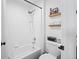 Clean bathroom featuring a tub with shower, a water-efficient toilet, and handy built-in shelving at 970 S Dawson Way # 9, Aurora, CO 80012