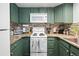 Close-up of kitchen featuring bright white appliances, earth-toned granite counters, and tiled backsplash at 970 S Dawson Way # 9, Aurora, CO 80012