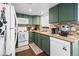Cozy kitchen features green cabinets, mosaic tile backsplash, and granite countertops at 970 S Dawson Way # 9, Aurora, CO 80012