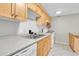 Kitchen view featuring wood cabinets, white appliances and tiled flooring at 2500 S York St # 115, Denver, CO 80210