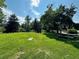 Serene park featuring green grass, mature trees, picnic area, and historic civil war cannon at 2500 S York St # 115, Denver, CO 80210