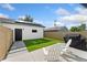 Inviting backyard with artificial turf, patio area with Adirondack chairs, and modern fence at 2426 Ames St, Edgewater, CO 80214