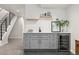 Basement wet bar featuring a mini fridge, undermount sink, floating shelves, and modern tiled backsplash at 2426 Ames St, Edgewater, CO 80214