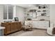 Basement area featuring custom built-in shelves, an accent chair, and vintage cabinet on neutral carpet at 2426 Ames St, Edgewater, CO 80214