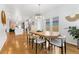 Open-concept dining area with a unique wooden table, stylish chairs, and view of the living and kitchen areas at 2426 Ames St, Edgewater, CO 80214