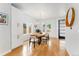 Bright dining room featuring a wooden table, modern light fixture, and ample natural light from large windows at 2426 Ames St, Edgewater, CO 80214