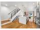 Modern kitchen with white cabinets, a center island, stainless steel appliances, and a staircase at 2426 Ames St, Edgewater, CO 80214