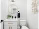 Stylish powder room with modern fixtures, a round mirror, and clean, bright design elements at 2426 Ames St, Edgewater, CO 80214