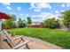 Backyard view of a wooden deck with chairs, lawn, and mature trees on a sunny day at 11100 Callaway Ct, Parker, CO 80138