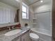 Bright bathroom with granite countertop vanity, white tub, and modern fixtures at 10307 Vaughn Way, Commerce City, CO 80022