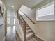 Hallway with wood floors and staircase featuring modern railings and natural light at 10307 Vaughn Way, Commerce City, CO 80022
