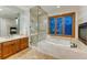 A relaxing bathroom featuring a glass enclosed shower, soaking tub, and double sink vanity with wood cabinets at 2597 Oak Vista Ct, Castle Rock, CO 80104