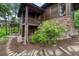 Wood and stone home exterior with a stone path, mature landscaping, and a balcony at 2597 Oak Vista Ct, Castle Rock, CO 80104
