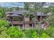Aerial shot of a luxury wood and stone home with multiple decks surrounded by mature trees at 2597 Oak Vista Ct, Castle Rock, CO 80104