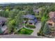 Nestled among mature trees, this house features lush landscaping, a circular driveway, and meticulous lawn at 2597 Oak Vista Ct, Castle Rock, CO 80104