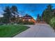A home's exterior is bathed in evening light, showcasing its lovely landscaping and driveway at 2597 Oak Vista Ct, Castle Rock, CO 80104