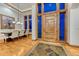 Elegant foyer with a large wooden door, stone flooring, and views of the dining area at 2597 Oak Vista Ct, Castle Rock, CO 80104