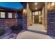 Inviting front porch with stone pillars, wood accents, and a grand entrance door at 2597 Oak Vista Ct, Castle Rock, CO 80104