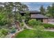 Lush front yard showcasing a waterfall feature, rock accents, and mature landscaping surrounding the home at 2597 Oak Vista Ct, Castle Rock, CO 80104