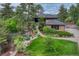Inviting front yard featuring lush landscaping, stone accents, a waterfall feature, and a walkway leading to the entrance at 2597 Oak Vista Ct, Castle Rock, CO 80104