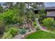 Well-manicured front yard with a stone waterfall feature, mature landscaping, and a walkway to the front door at 2597 Oak Vista Ct, Castle Rock, CO 80104