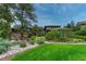 Picturesque front yard featuring a waterfall, lush greenery, and a well-manicured lawn leading to the house at 2597 Oak Vista Ct, Castle Rock, CO 80104