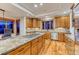 Gourmet kitchen with large granite island, stainless appliances, custom cabinets, and hardwood flooring at 2597 Oak Vista Ct, Castle Rock, CO 80104