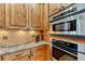Kitchen showcasing stainless steel double oven, wood cabinets and granite counter at 2597 Oak Vista Ct, Castle Rock, CO 80104