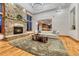 Cozy living room with a stone fireplace, plush rug, and an open layout to the kitchen at 2597 Oak Vista Ct, Castle Rock, CO 80104